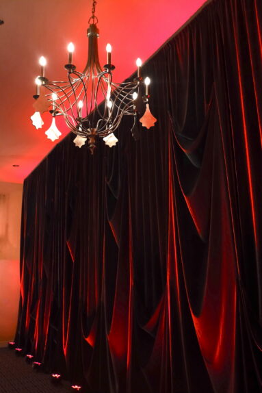 Sophisticated pin-tucked styled drape wall with lighting design